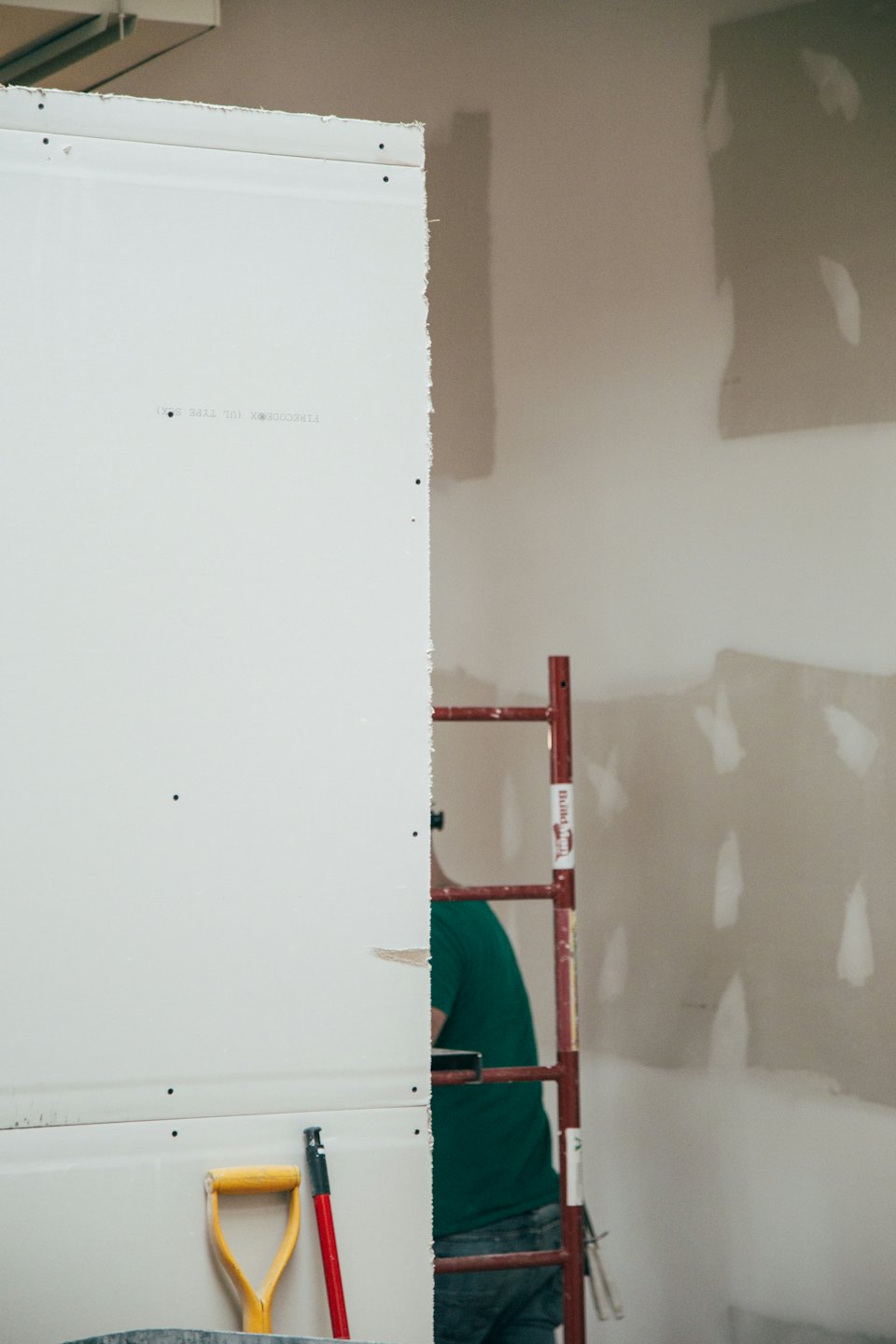 Operaio edile installa cartongesso in una nuova stanza interna.